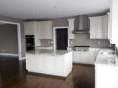 Kitchen with large island, hardwood floors, and opening to dining room