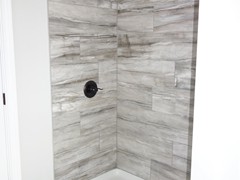 Standard shower with tiled shower walls.