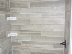 Bathroom tub with standard ceramic tile walls.