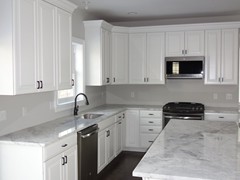 Kitchen with standard granite countertops and natural hardwood flooring.  Ceramic tile also available.